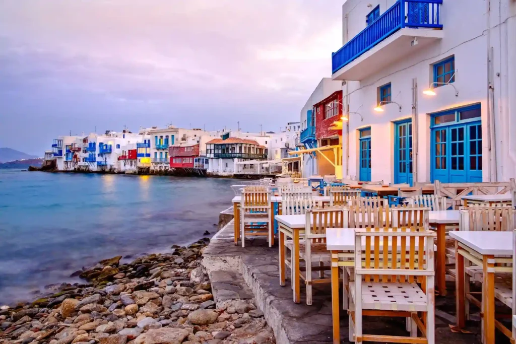 a group of tables and chairs on a rocky shore Mykonos Island